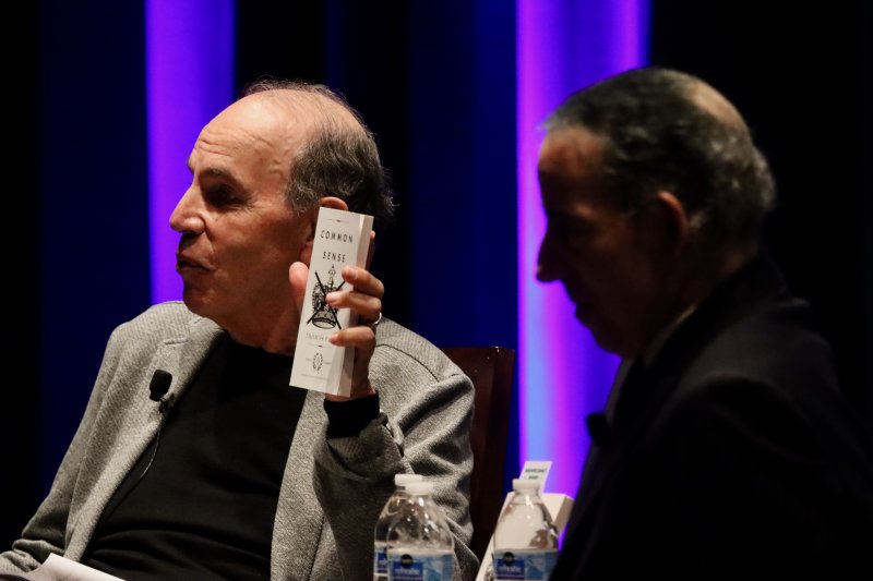 Ron Collins holds a copy of Common Sense, which was available for purchase at the event.